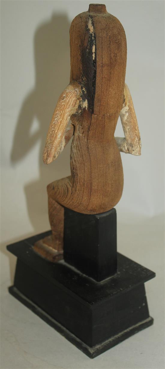 A carved wood figure of a seated ancient Egyptian woman, 12in.